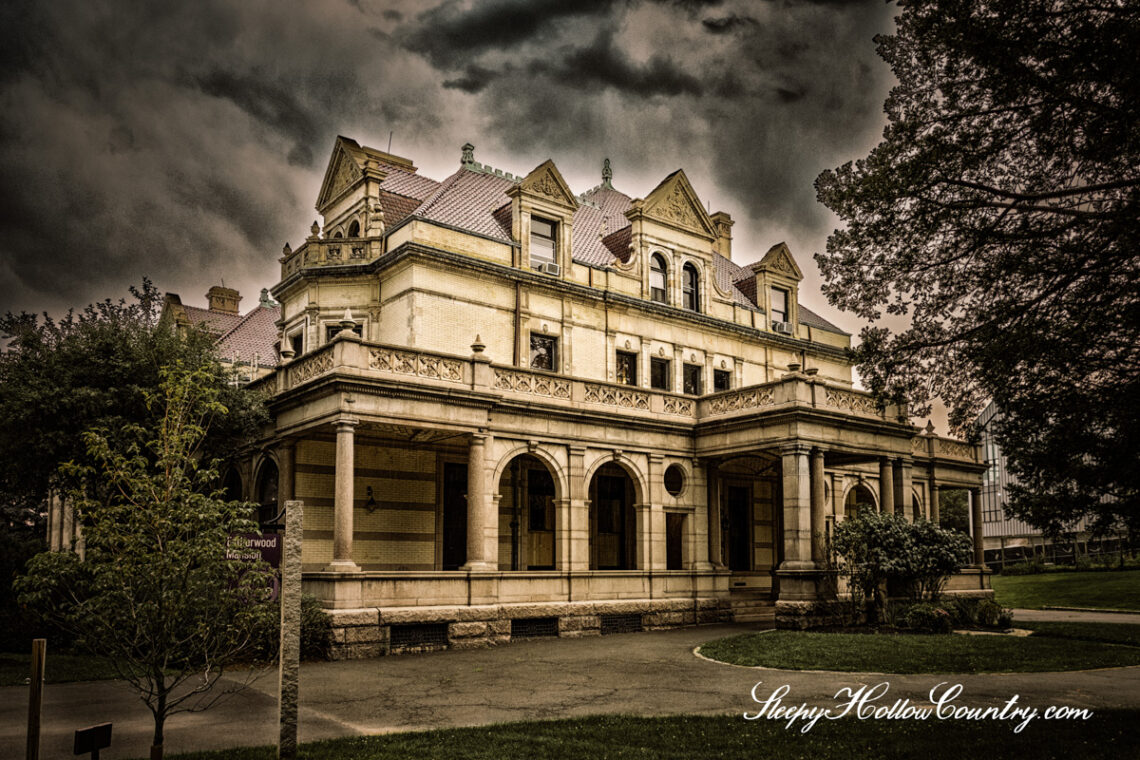 The exterior of the Estherwood mansion is framed against an ominously dark sky.