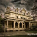 The exterior of the Estherwood mansion is framed against an ominously dark sky.